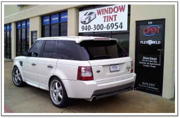 White Car Sitting in Front of Window Tint Sign